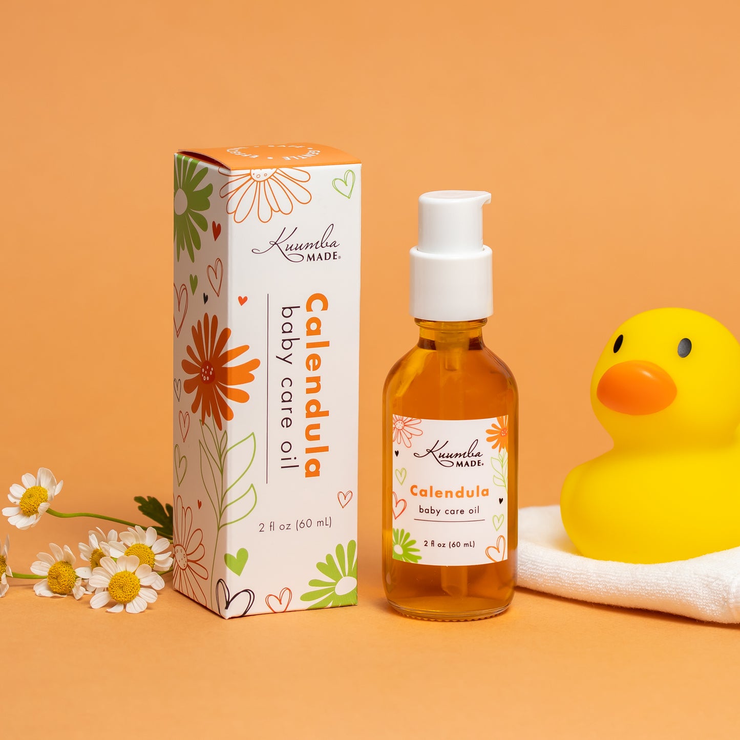 Kuumba Made Baby Care Oil with rubber duckie and little chamomile flowers